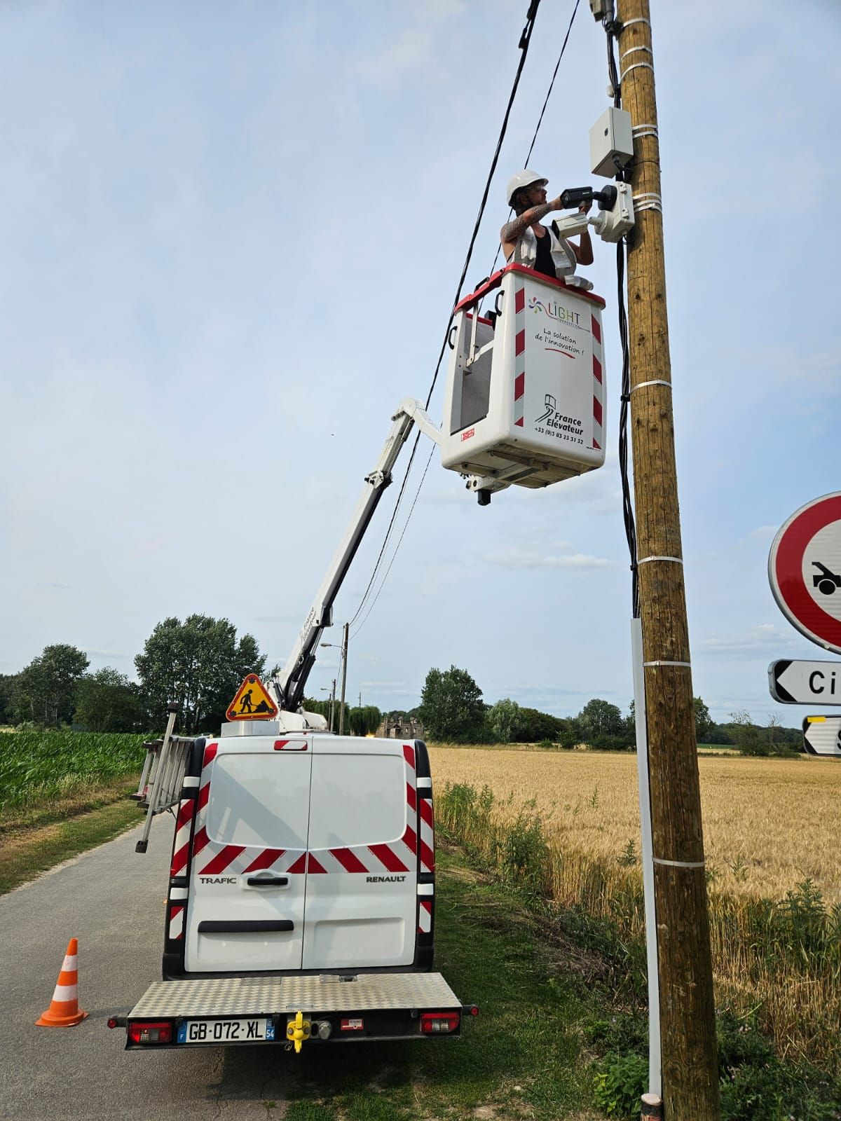 Technicien intervenant en hauteur sur une installation extérieure